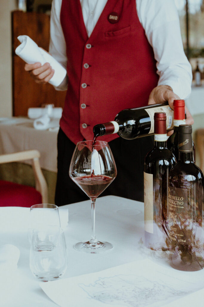 Sommelier che versa un calice di vino rosso